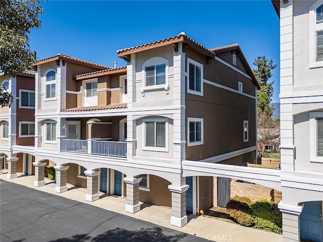 exterior space featuring stucco siding and a tile roof