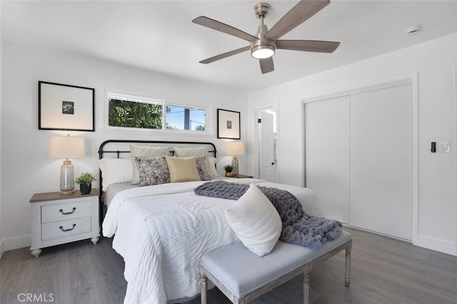 bedroom featuring a closet, baseboards, ceiling fan, and wood finished floors