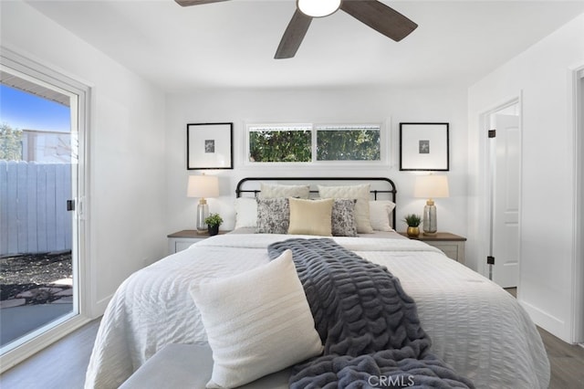 bedroom featuring multiple windows, baseboards, a ceiling fan, and wood finished floors