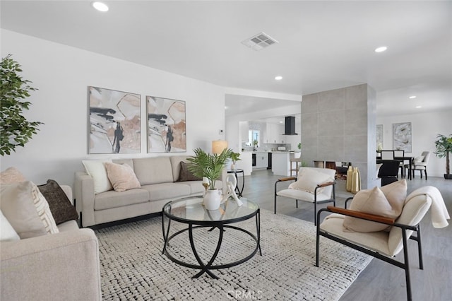 living area featuring visible vents, recessed lighting, and light wood-style floors