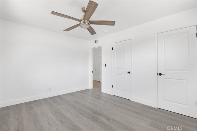 unfurnished bedroom with visible vents, ceiling fan, light wood-type flooring, and baseboards