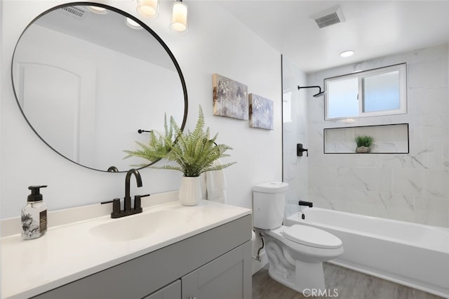 bathroom featuring visible vents, toilet, bathtub / shower combination, wood finished floors, and vanity