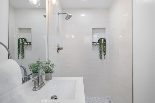 bathroom featuring a sink and a tile shower