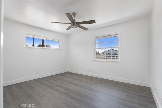 spare room with ceiling fan, baseboards, and dark wood-style floors