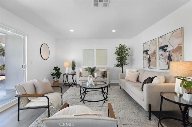 living area featuring visible vents, recessed lighting, baseboards, and wood finished floors