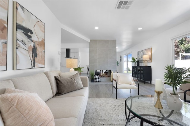 living area with light wood-style flooring, recessed lighting, and visible vents