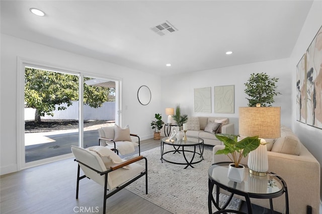 living area featuring visible vents, recessed lighting, baseboards, and wood finished floors