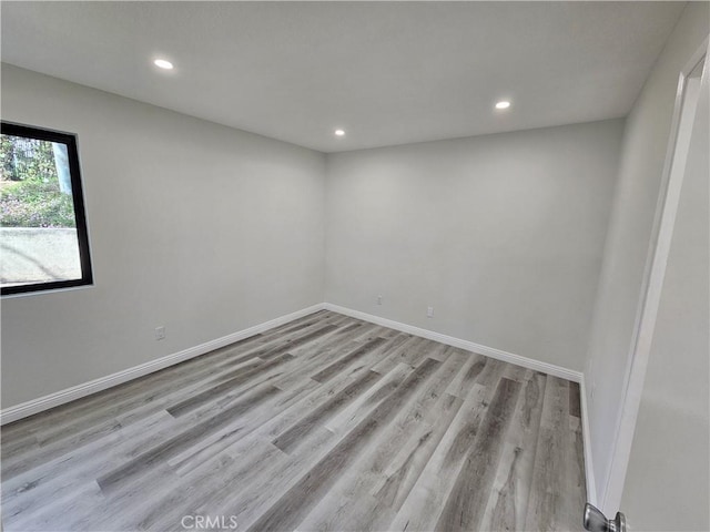 unfurnished room with recessed lighting, baseboards, and wood finished floors