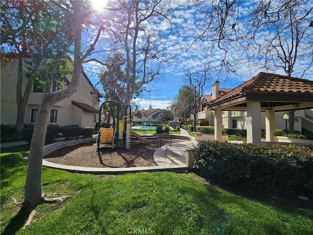 exterior space featuring playground community, a residential view, and a lawn