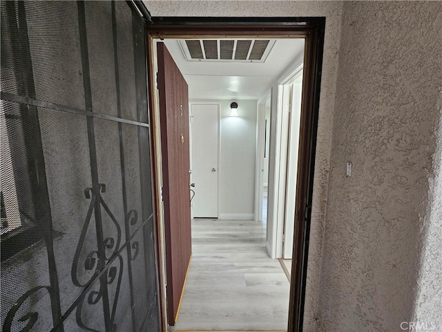 hall with visible vents and light wood-style floors