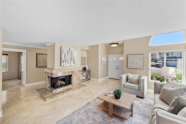 living room with a textured ceiling, crown molding, baseboards, and a premium fireplace