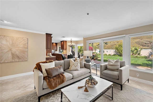 living room featuring an inviting chandelier, baseboards, and ornamental molding