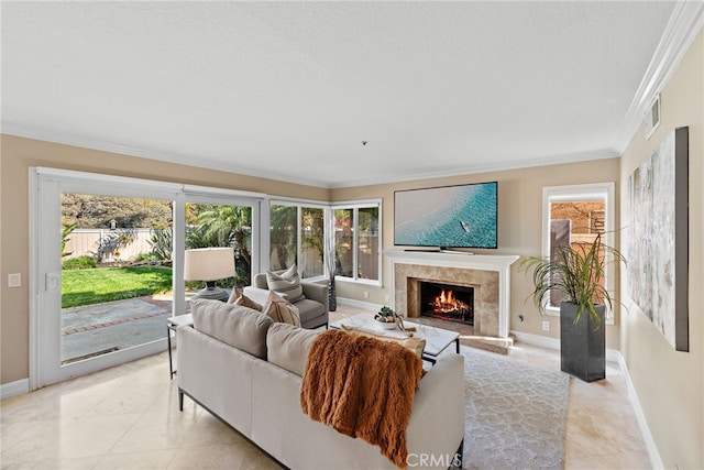 living area with a high end fireplace, visible vents, baseboards, and ornamental molding