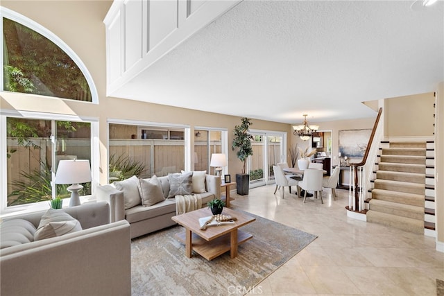 living area featuring light tile patterned floors, stairway, a textured ceiling, and an inviting chandelier