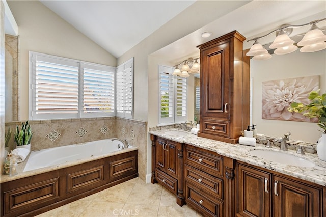 full bath featuring a sink, lofted ceiling, a bath, and tile patterned floors