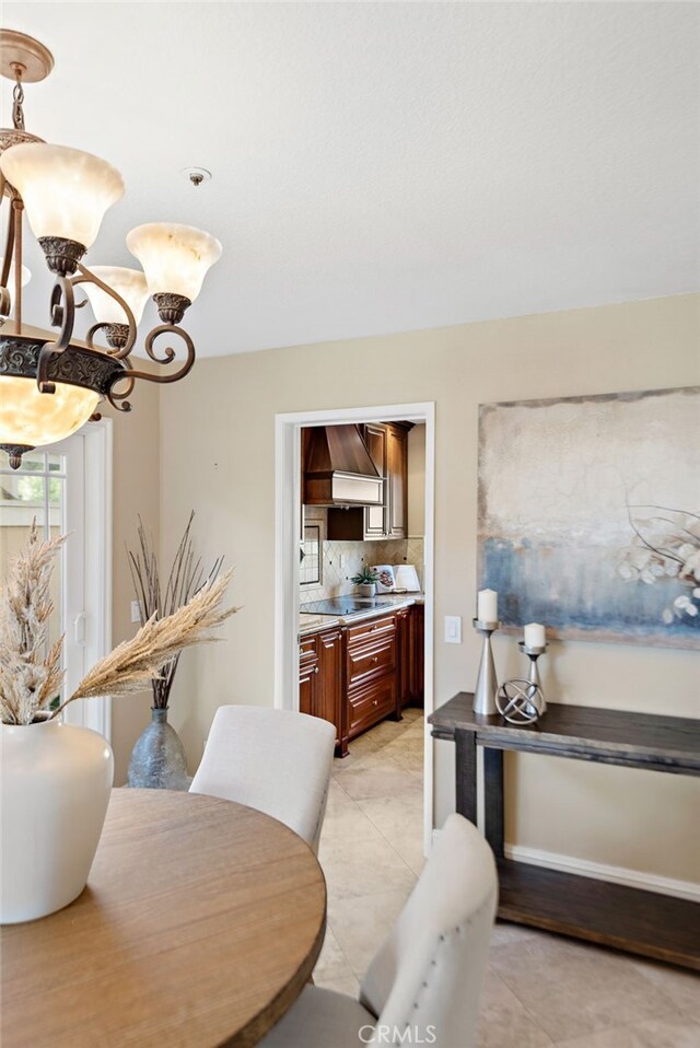 dining room with a notable chandelier and light tile patterned flooring