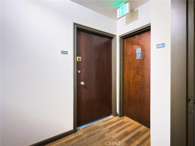 hall with baseboards and a textured ceiling