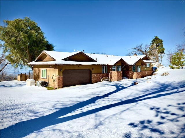 ranch-style home with brick siding, cooling unit, a garage, and fence