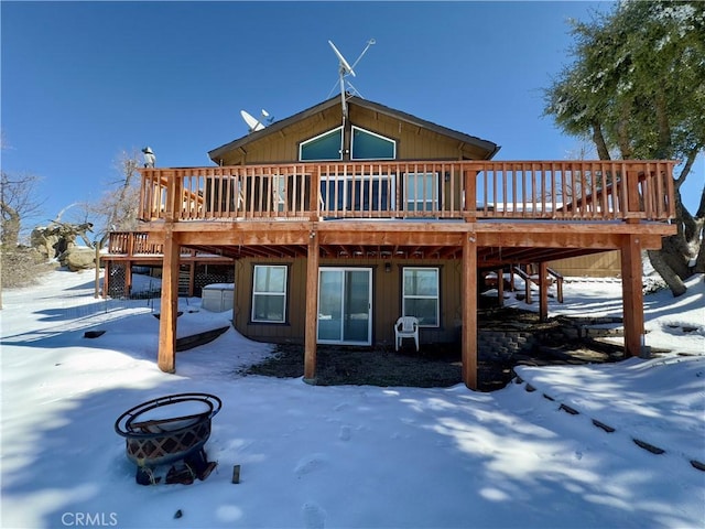 snow covered property with stairway and a deck