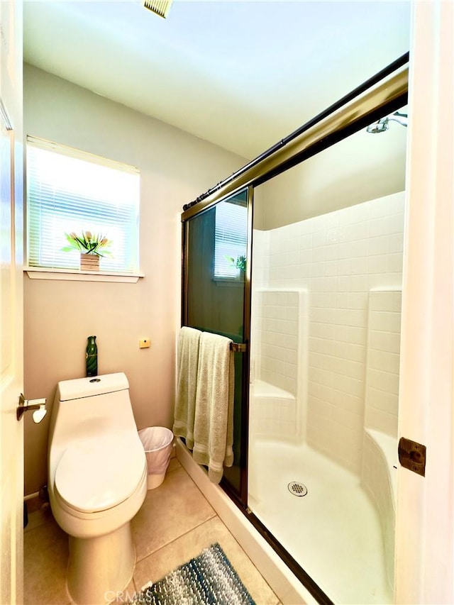 bathroom with toilet, tile patterned floors, and an enclosed shower