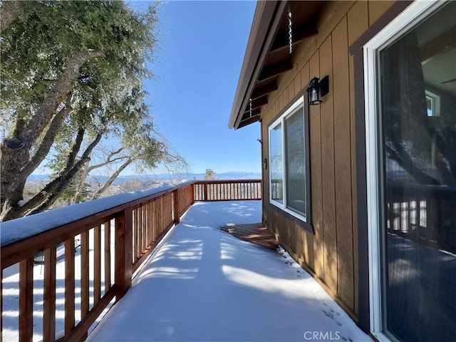 view of snow covered back of property