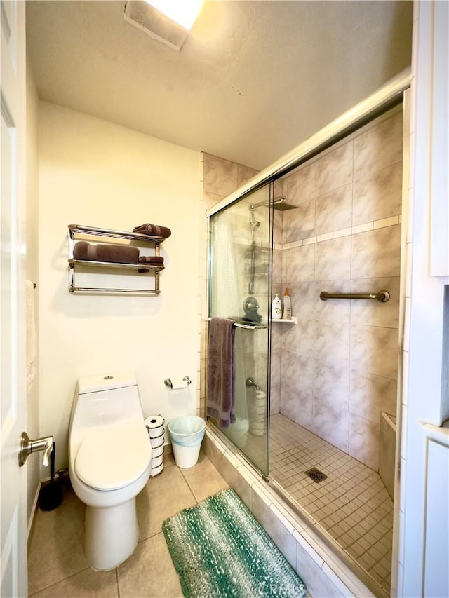 full bathroom featuring toilet, a stall shower, and tile patterned flooring