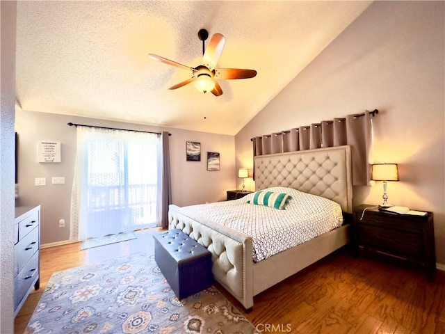 bedroom with ceiling fan, lofted ceiling, a textured ceiling, and wood finished floors