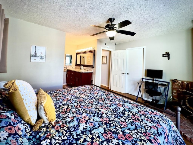 bedroom with connected bathroom, baseboards, ceiling fan, wood finished floors, and a textured ceiling