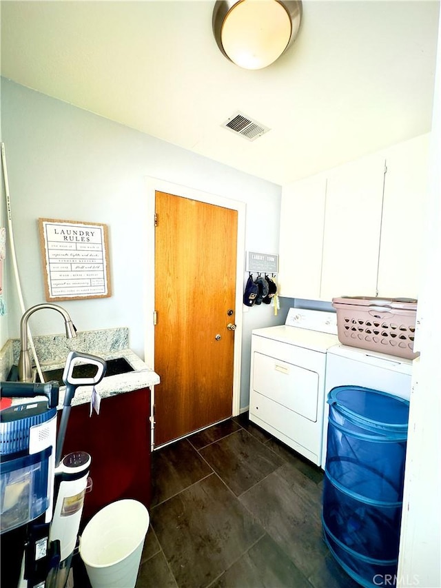 washroom with cabinet space, visible vents, and washing machine and clothes dryer