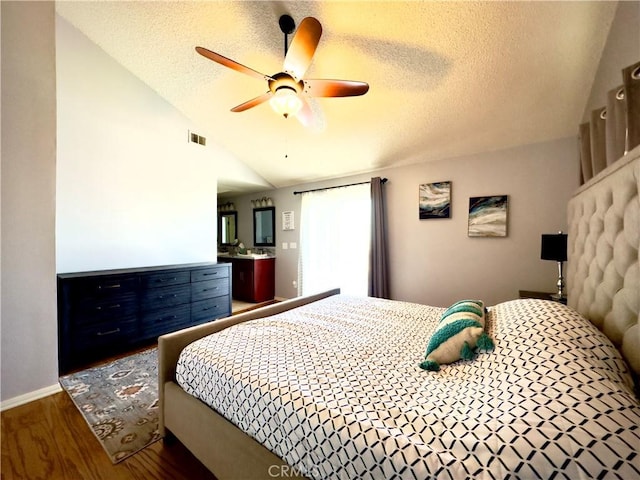 bedroom with wood finished floors, visible vents, lofted ceiling, ceiling fan, and a textured ceiling