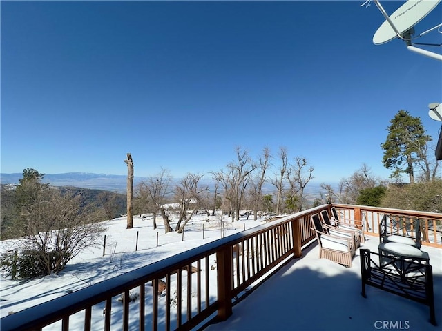 snow covered deck featuring a mountain view