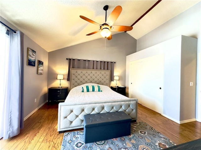 bedroom with baseboards, wood finished floors, a ceiling fan, and vaulted ceiling