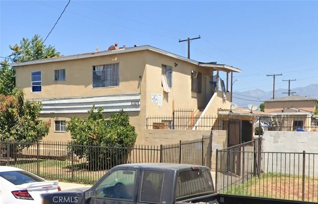 view of front of home featuring stucco siding and fence