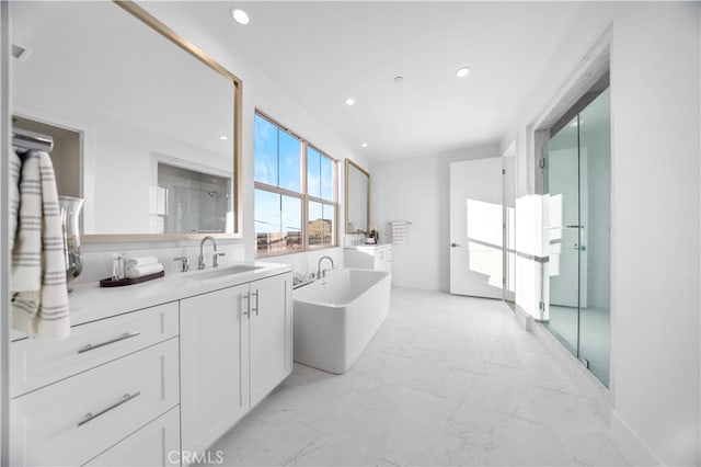 full bathroom featuring walk in shower, recessed lighting, a freestanding tub, marble finish floor, and vanity