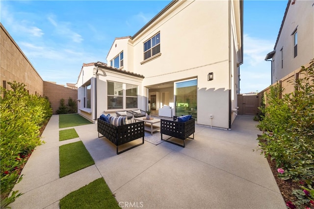 rear view of house with a patio, a fenced backyard, stucco siding, a tiled roof, and an outdoor hangout area