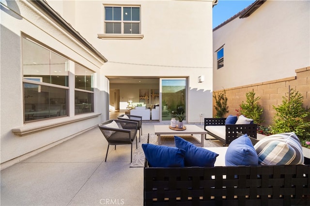 view of patio featuring an outdoor hangout area and fence