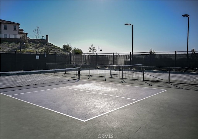 view of sport court featuring fence