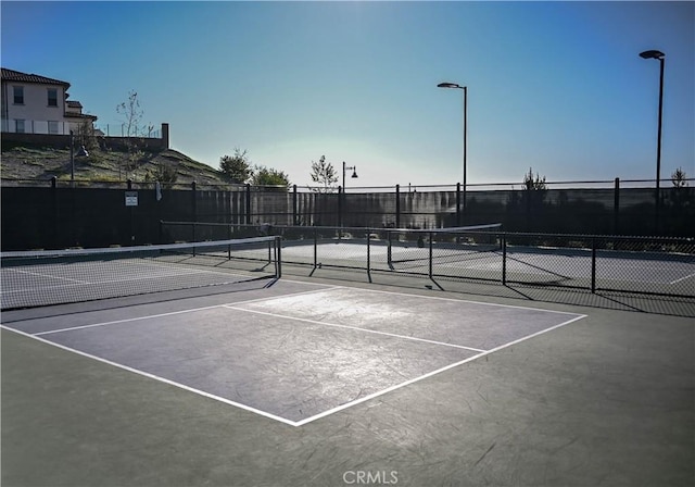 view of tennis court with fence