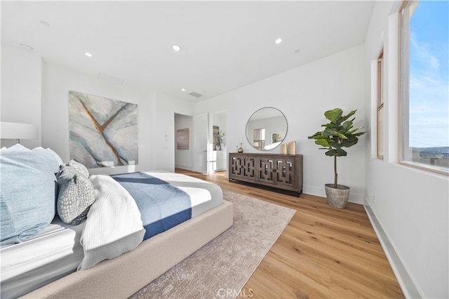 bedroom with baseboards, recessed lighting, and light wood-type flooring
