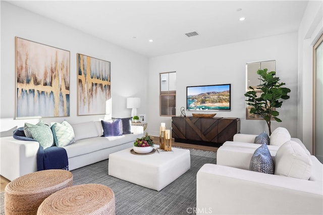 living area featuring recessed lighting, visible vents, and wood finished floors