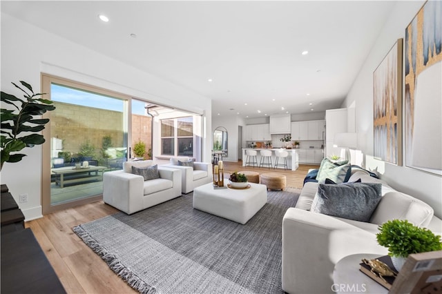 living area featuring light wood-type flooring and recessed lighting