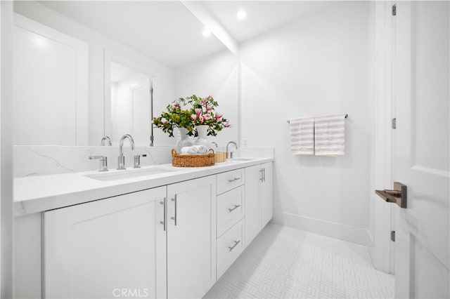 full bathroom featuring double vanity, tile patterned flooring, a sink, and baseboards