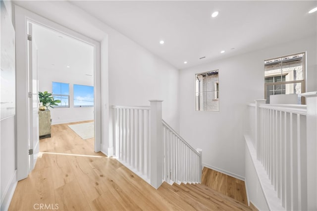 hall with recessed lighting, an upstairs landing, baseboards, and wood finished floors