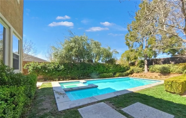 view of swimming pool with a fenced backyard and a pool with connected hot tub