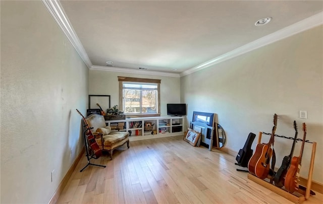 living area featuring visible vents, baseboards, light wood-type flooring, and ornamental molding