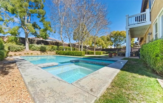 view of swimming pool featuring fence and a pool with connected hot tub