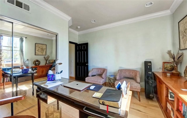 office space with light wood finished floors, visible vents, and ornamental molding