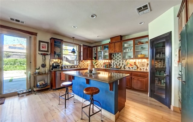 kitchen featuring backsplash, visible vents, and light wood-style flooring