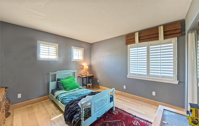 bedroom featuring baseboards and wood finished floors