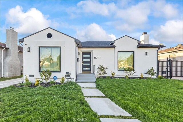 ranch-style home with stucco siding, a chimney, a front lawn, and fence